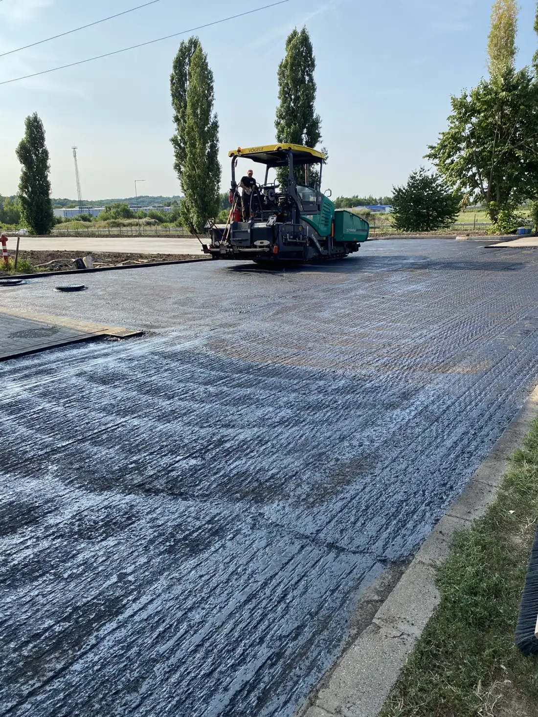Aszfaltszóró finiher friss aszfaltréteget terít — aszfaltozás Debrecen térségében